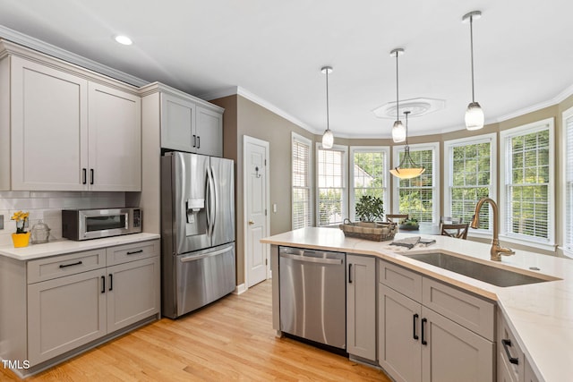 100 Beraneak Ln, Cary, NC 27519 - kitchen featuring stainless steel appliances, crown molding, gray cabinets, light wood-style floors, and decorative light fixtures