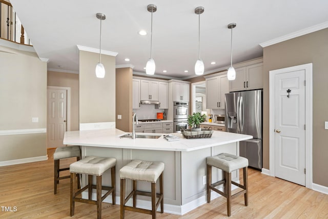 100 Beraneak Ln, Cary, NC 27519 - kitchen with appliances with stainless steel finishes, ornamental molding, a peninsula, a breakfast bar area, and light wood finished floors