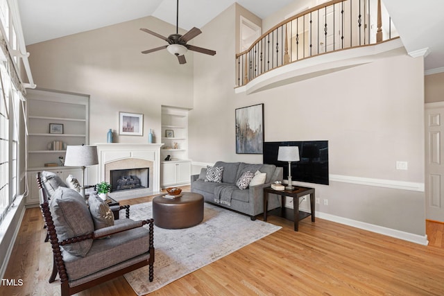 100 Beraneak Ln, Cary, NC 27519 - living area featuring wood finished floors, a ceiling fan, a premium fireplace, high vaulted ceiling, and built in features