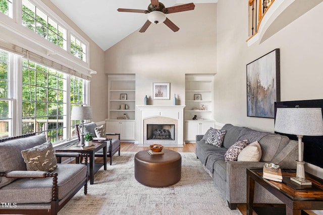 100 Beraneak Ln, Cary, NC 27519 - living room featuring a ceiling fan, high vaulted ceiling, light wood finished floors, plenty of natural light, and a fireplace