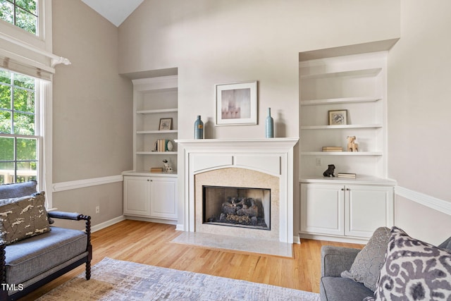 100 Beraneak Ln, Cary, NC 27519 - living room featuring light wood-style floors, a fireplace with flush hearth, high vaulted ceiling, and built in features