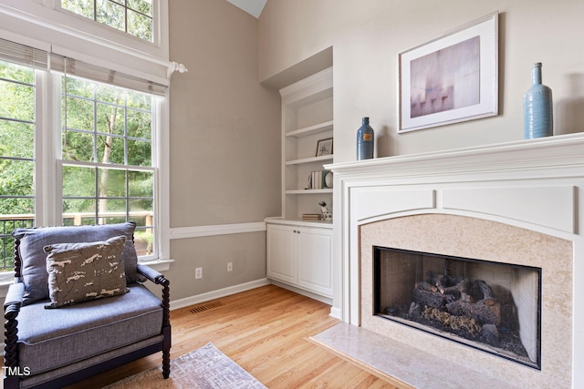 100 Beraneak Ln, Cary, NC 27519 - living area featuring a high end fireplace, light wood-style floors, plenty of natural light, and built in shelves
