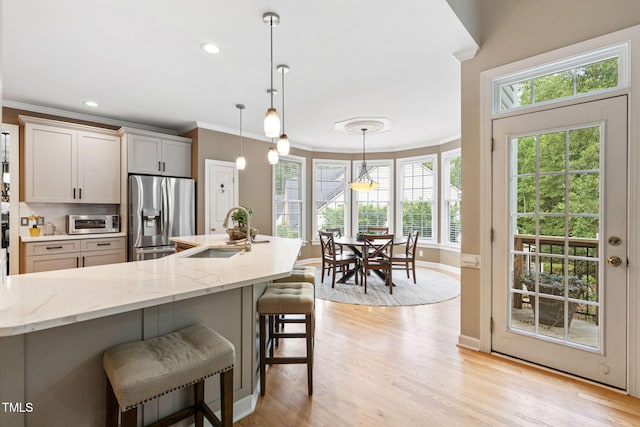 100 Beraneak Ln, Cary, NC 27519 - kitchen with appliances with stainless steel finishes, ornamental molding, a breakfast bar, decorative backsplash, and light stone countertops