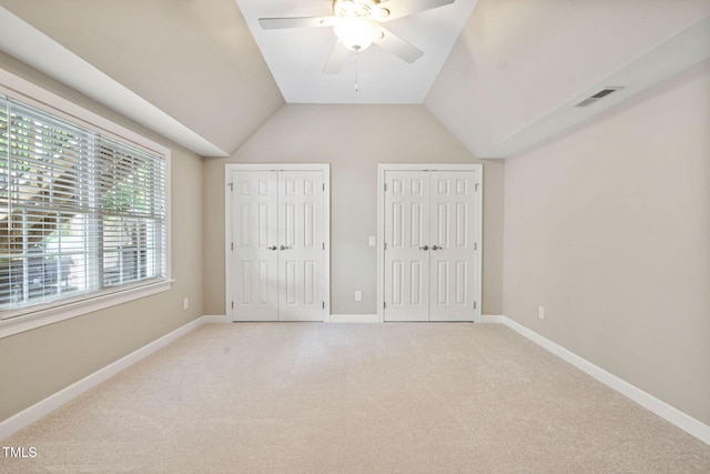 100 Beraneak Ln, Cary, NC 27519 - unfurnished bedroom with two closets, light carpet, lofted ceiling, and a ceiling fan