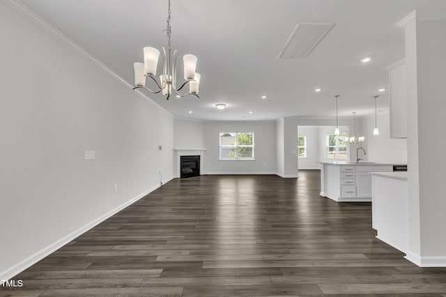 2307 Bethpage Dr, Fuquay Varina, NC 27526 - unfurnished living room with recessed lighting, ornamental molding, dark wood-style flooring, a chandelier, and a glass covered fireplace