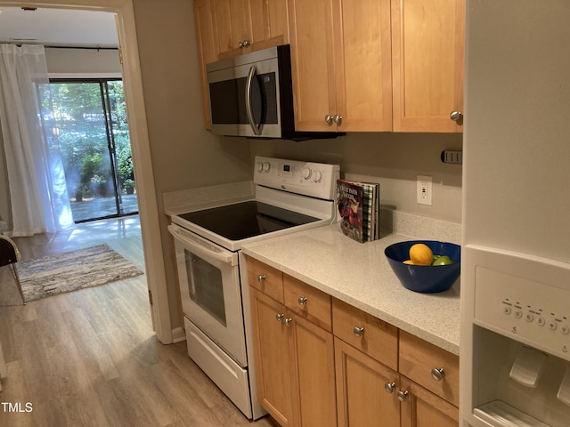 3082 Colony Rd Unit A, Durham, NC 27705 - kitchen featuring electric stove, stainless steel microwave, light wood-style flooring, and light stone countertops