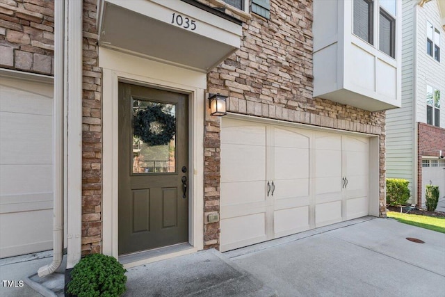 1035 Brownsmith Dr, Apex, NC 27502 - view of exterior entry with stone siding, concrete driveway, and an attached garage