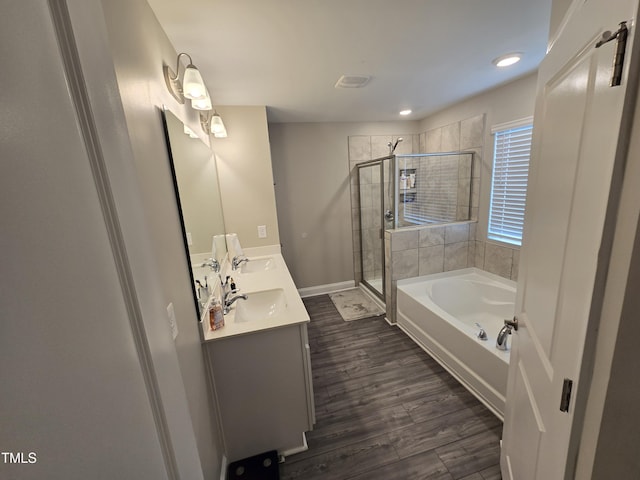 808 Heartpine Dr, Mebane, NC 27302 - bathroom with double vanity, a shower stall, a garden tub, wood finished floors, and recessed lighting