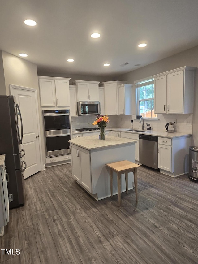808 Heartpine Dr, Mebane, NC 27302 - kitchen featuring appliances with stainless steel finishes, white cabinetry, dark wood-type flooring, and recessed lighting