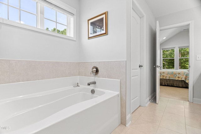 121 Roundrock Ln, Sanford, NC 27330 - ensuite bathroom featuring a bath, tile patterned flooring, and vaulted ceiling