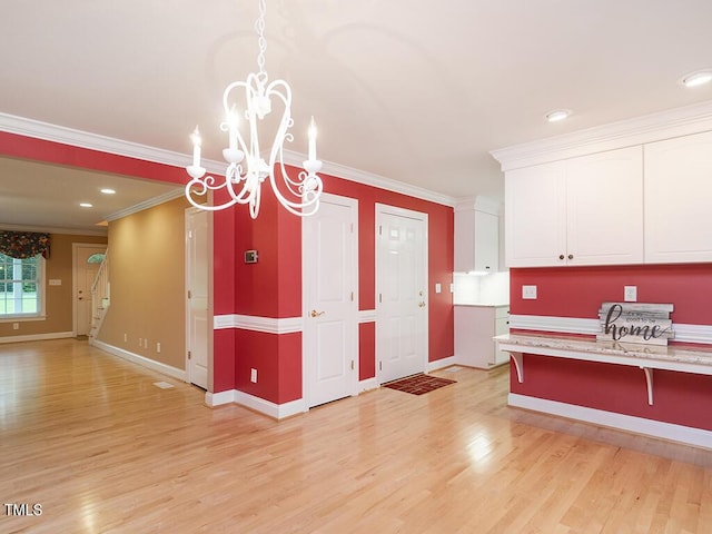 6843 Sawyer Rd, Liberty, NC 27298 - kitchen featuring white cabinets, crown molding, a chandelier, light wood-style floors, and a breakfast bar