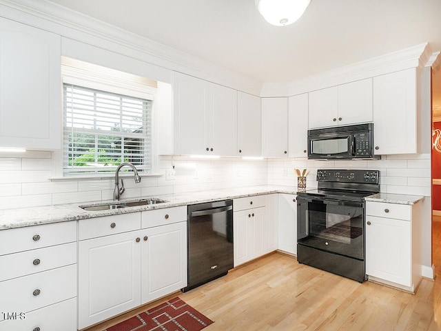 6843 Sawyer Rd, Liberty, NC 27298 - kitchen featuring black appliances, light wood-type flooring, backsplash, white cabinetry, and light stone countertops