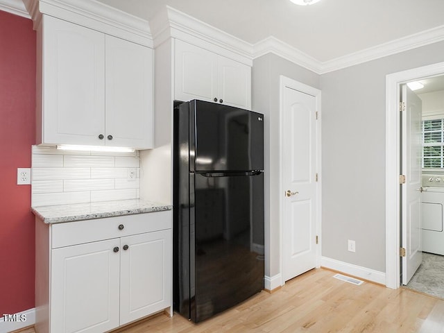 6843 Sawyer Rd, Liberty, NC 27298 - kitchen with freestanding refrigerator, light wood finished floors, white cabinetry, tasteful backsplash, and washer / clothes dryer