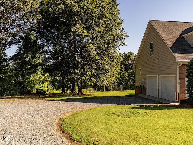 6843 Sawyer Rd, Liberty, NC 27298 - view of side of home featuring driveway, a shingled roof, a yard, brick siding, and a garage