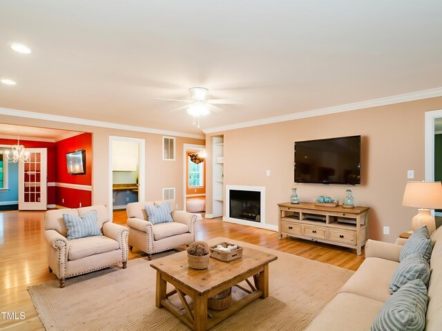 6843 Sawyer Rd, Liberty, NC 27298 - living area with light wood finished floors, a chandelier, ornamental molding, ceiling fan, and a fireplace