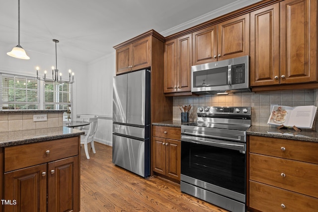 6104 Spicewood Dr, Fuquay Varina, NC 27526 - kitchen with stainless steel appliances, a chandelier, dark wood-style flooring, backsplash, and brown cabinets