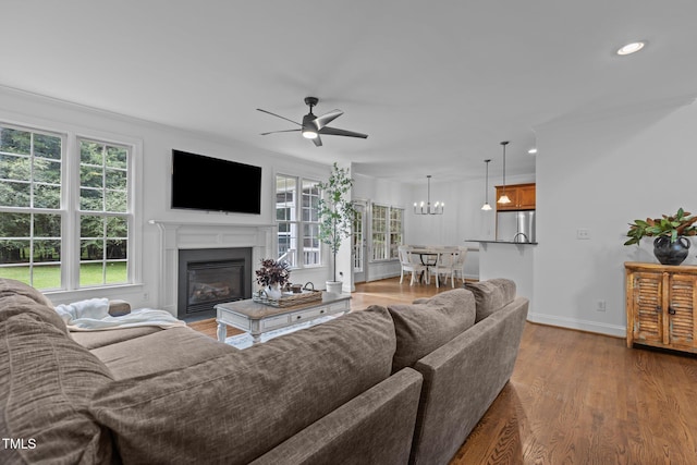6104 Spicewood Dr, Fuquay Varina, NC 27526 - living room with a ceiling fan, a glass covered fireplace, wood finished floors, a chandelier, and recessed lighting