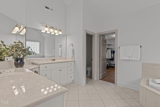 6104 Spicewood Dr, Fuquay Varina, NC 27526 - bathroom featuring vanity, tile patterned flooring, a garden tub, a walk in closet, and high vaulted ceiling