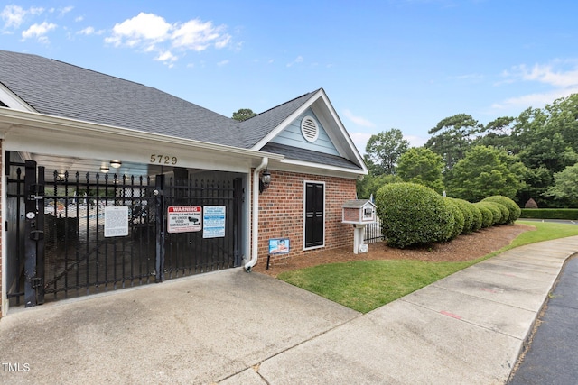 6104 Spicewood Dr, Fuquay Varina, NC 27526 - view of side of property with brick siding, concrete driveway, an attached garage, roof with shingles, and a gate