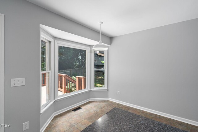 2912 Enson Pl, Raleigh, NC 27603 - unfurnished dining area with plenty of natural light and stone tile floors