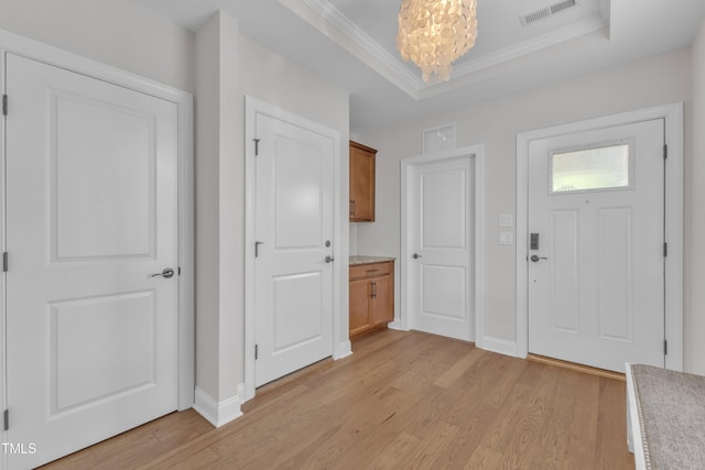 1003 Branwell Dr, Durham, NC 27703 - entrance foyer with a chandelier, light wood-type flooring, ornamental molding, and a raised ceiling