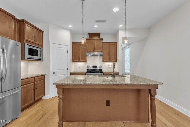 1003 Branwell Dr, Durham, NC 27703 - kitchen with appliances with stainless steel finishes, backsplash, light wood-style flooring, brown cabinetry, and recessed lighting