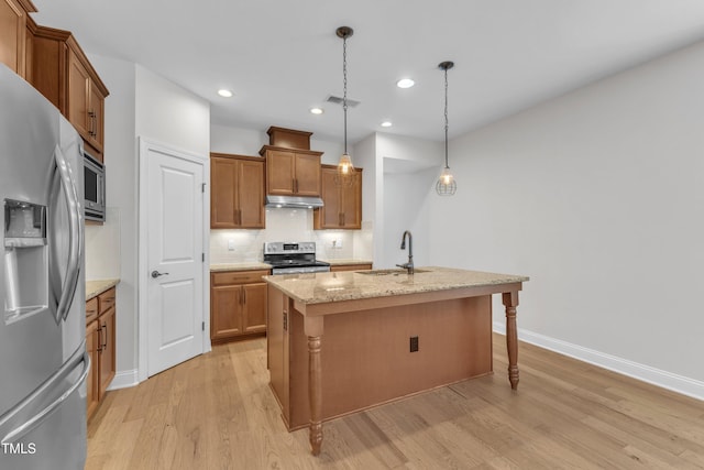 1003 Branwell Dr, Durham, NC 27703 - kitchen with appliances with stainless steel finishes, under cabinet range hood, light wood-style flooring, brown cabinets, and recessed lighting