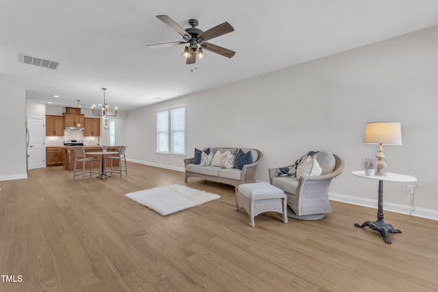 1003 Branwell Dr, Durham, NC 27703 - living room featuring light wood finished floors, a ceiling fan, and a chandelier