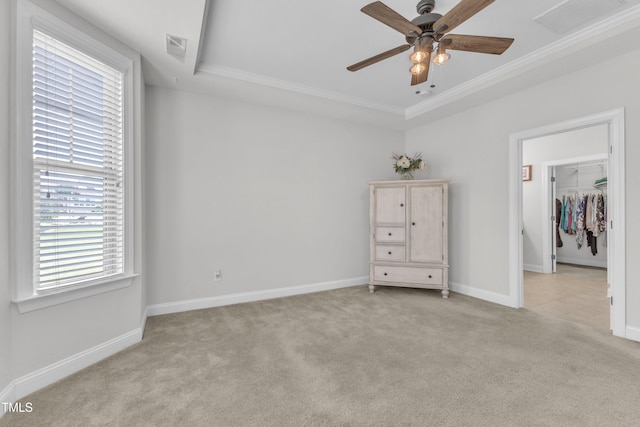 1003 Branwell Dr, Durham, NC 27703 - bedroom featuring light colored carpet, a tray ceiling, crown molding, a walk in closet, and ceiling fan