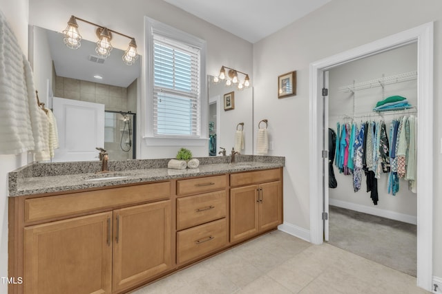 1003 Branwell Dr, Durham, NC 27703 - bathroom featuring a stall shower, double vanity, and a spacious closet