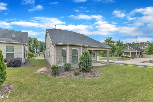 1003 Branwell Dr, Durham, NC 27703 - view of side of home with a lawn and a central AC unit