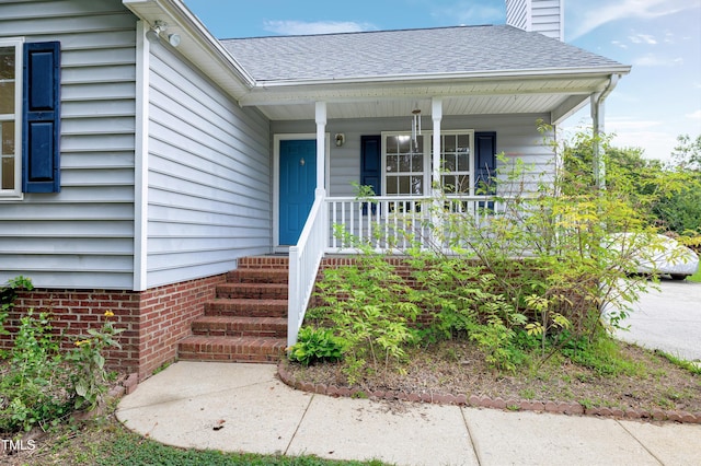 405 E Maple Ave, Holly Springs, NC 27540 - entrance to property featuring covered porch, a shingled roof, and a chimney