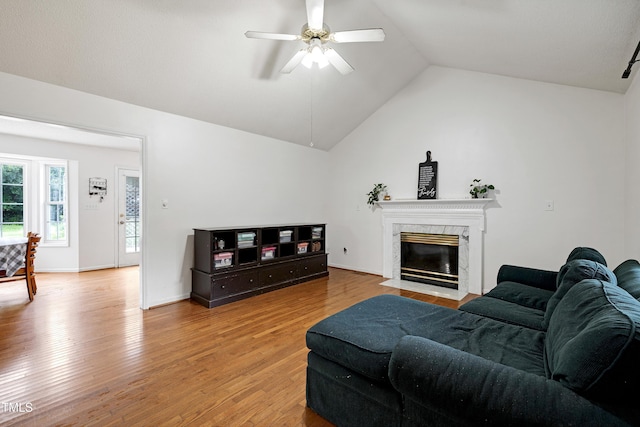 405 E Maple Ave, Holly Springs, NC 27540 - living area featuring a ceiling fan, lofted ceiling, light wood-style floors, and a premium fireplace