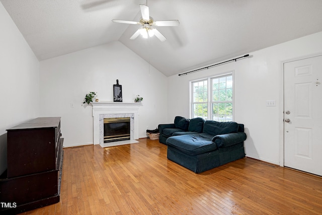 405 E Maple Ave, Holly Springs, NC 27540 - living area featuring light wood-style flooring, ceiling fan, vaulted ceiling, and a high end fireplace