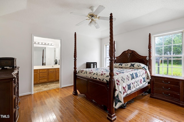 405 E Maple Ave, Holly Springs, NC 27540 - bedroom with light wood-style flooring, ensuite bath, a textured ceiling, and a ceiling fan