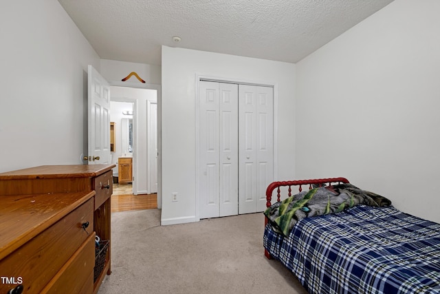405 E Maple Ave, Holly Springs, NC 27540 - bedroom with light colored carpet, a closet, and a textured ceiling