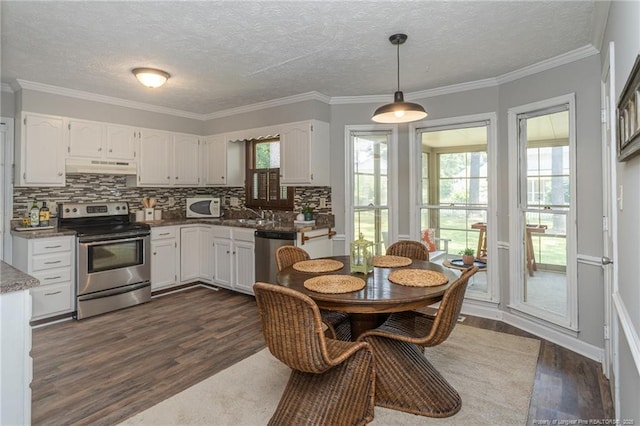 3516 Worley St, Fayetteville, NC 28311 - kitchen featuring stainless steel appliances, dark wood finished floors, under cabinet range hood, backsplash, and white cabinetry