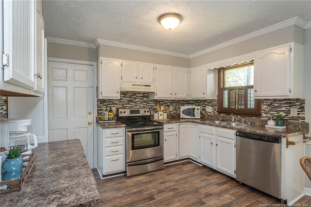 3516 Worley St, Fayetteville, NC 28311 - kitchen with appliances with stainless steel finishes, dark countertops, under cabinet range hood, white cabinetry, and decorative backsplash