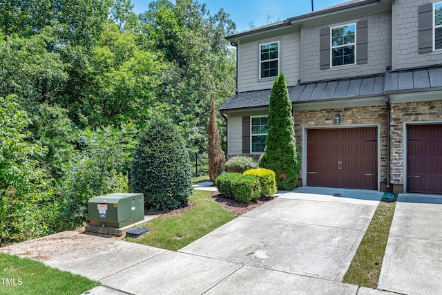 677 Wickham Ridge Rd, Apex, NC 27539 - view of front of house with a standing seam roof, a garage, driveway, and a metal roof