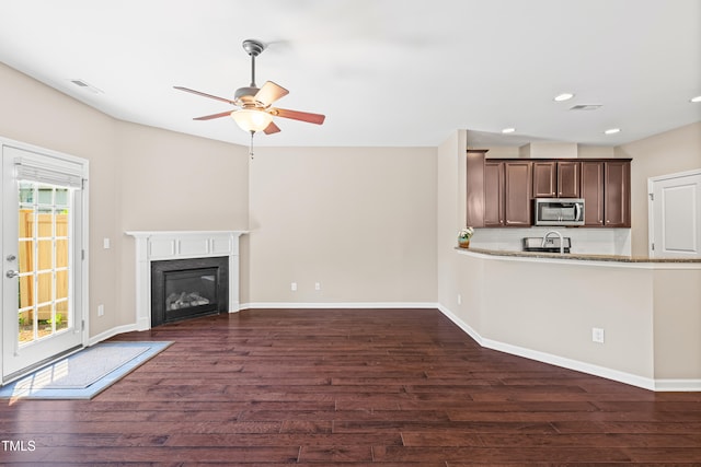677 Wickham Ridge Rd, Apex, NC 27539 - unfurnished living room with a ceiling fan, dark wood-style flooring, recessed lighting, and a glass covered fireplace