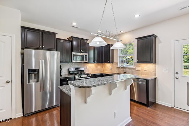 4 Seawell Ct, Durham, NC 27703 - kitchen with appliances with stainless steel finishes, light stone counters, dark wood finished floors, and recessed lighting