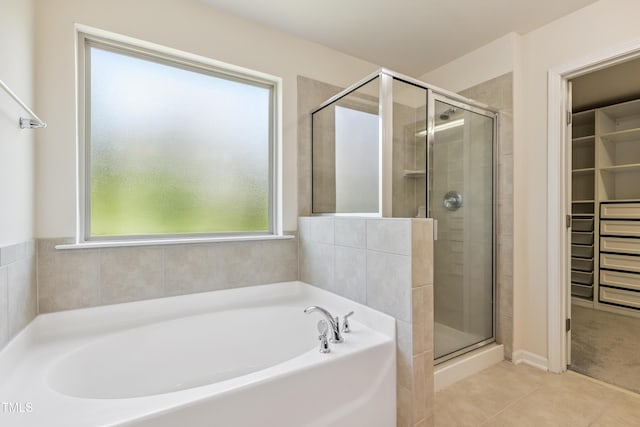 4 Seawell Ct, Durham, NC 27703 - full bathroom featuring a spacious closet, a garden tub, a shower stall, and tile patterned floors