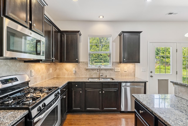 4 Seawell Ct, Durham, NC 27703 - kitchen featuring stainless steel appliances, light stone countertops, wood finished floors, tasteful backsplash, and recessed lighting