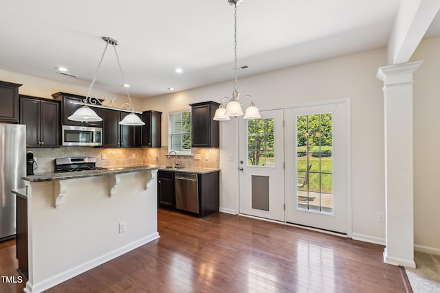 4 Seawell Ct, Durham, NC 27703 - kitchen featuring stainless steel appliances, a kitchen breakfast bar, backsplash, stone counters, and dark wood finished floors