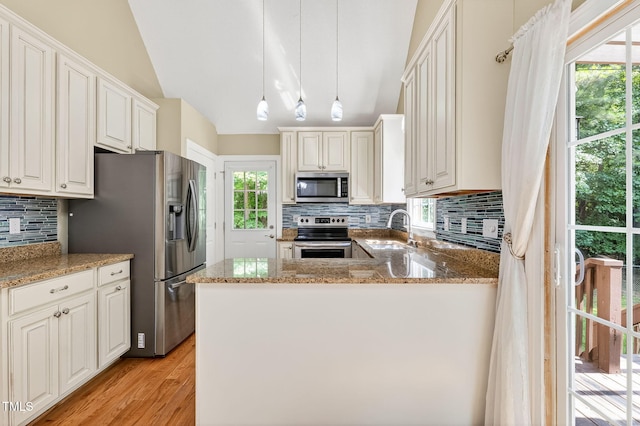 116 Seminole Dr, Louisburg, NC 27549 - kitchen with appliances with stainless steel finishes, light wood-style flooring, tasteful backsplash, vaulted ceiling, and light stone countertops