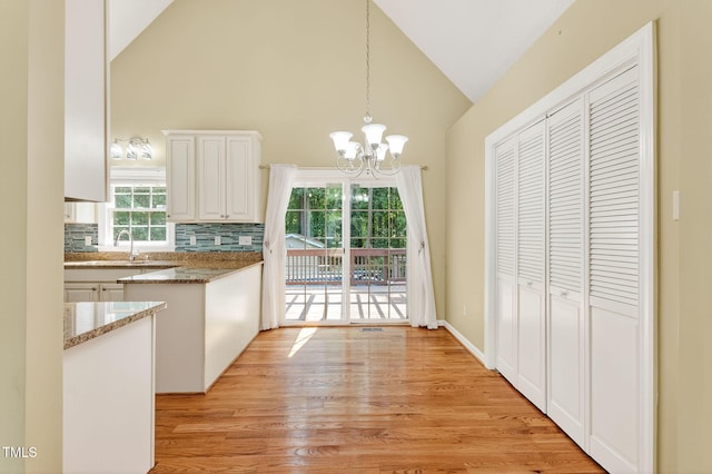 116 Seminole Dr, Louisburg, NC 27549 - kitchen with a chandelier, high vaulted ceiling, light wood-type flooring, decorative light fixtures, and white cabinetry
