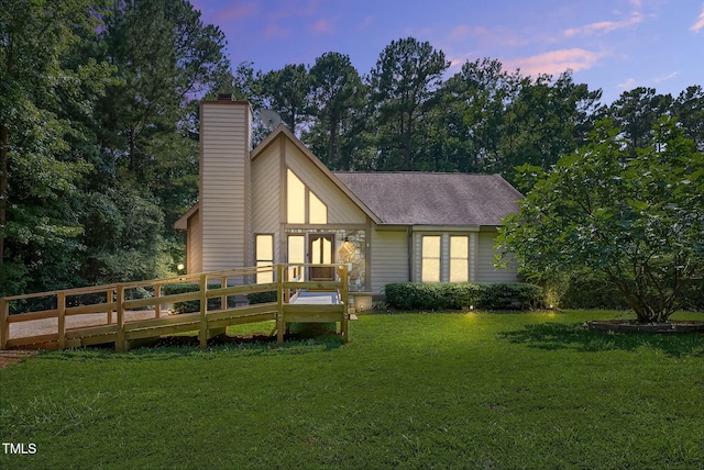 116 Seminole Dr, Louisburg, NC 27549 - back of property at dusk featuring a yard, a chimney, a shingled roof, and a wooden deck