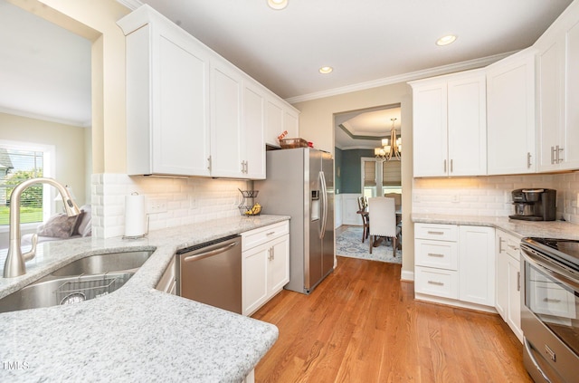 141 Vibernum Vw, Four Oaks, NC 27524 - kitchen with stainless steel appliances, ornamental molding, a chandelier, white cabinetry, and light stone counters