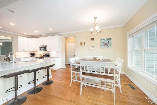 141 Vibernum Vw, Four Oaks, NC 27524 - dining area featuring a chandelier, crown molding, light wood-type flooring, plenty of natural light, and recessed lighting