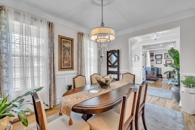 126 Gwendolyn Way, Fuquay Varina, NC 27526 - dining area featuring a chandelier, crown molding, light wood-style flooring, and a wainscoted wall